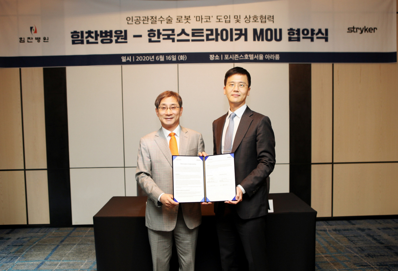 [사진설명: 이수찬 힘찬병원 대표원장(좌)과 심현우 한국스트라이커 대표이사(우)가 업무 협약 체결 후 기념사진을 찍고 있다. ]