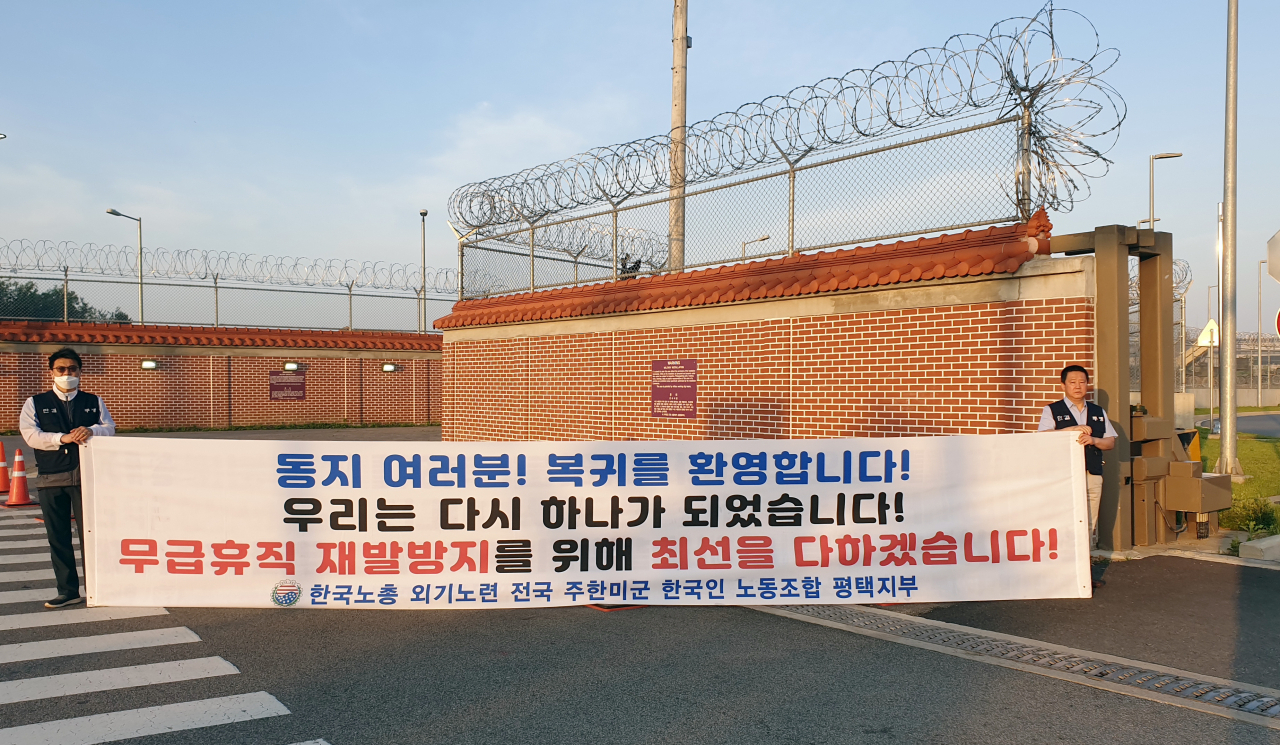 주한미군 한국인 근로자들이 75일간의 무급휴직을 거쳐 재출근을 시작한 15일 오전 경기도 평택시 캠프 험프리스 앞에서 전국 주한미군 한국인 노조 관계자들이 환영 현수막을 걸고 출근 인사를 하고 있다. 연합뉴스
