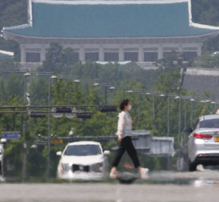 서울 등 내륙 곳곳에 올여름 첫 폭염주의보가 내려진 지난 8일 오후 서울 종로구 세종대로에서 시민이 지열로 아지랑이가 피어오르는 횡단보도 위를 지나고 있다. [연합]