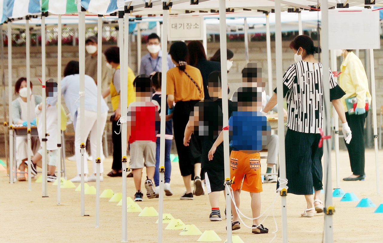 인천지역 신종 코로나바이러스 감염증(코로나19) 확진자가 속출한 17일 오전 확진자가 나온 인천시 미추홀구 한 초등학교에서 학생들이 운동장에 마련된 선별진료소로 들어서고 있다. [연합]