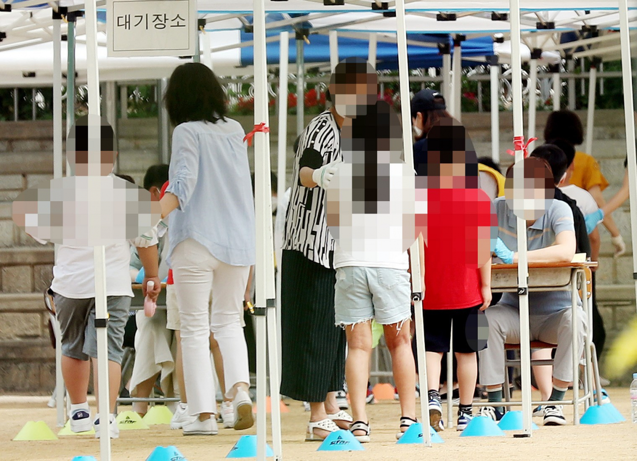 인천지역 신종 코로나바이러스 감염증(코로나19) 확진자가 속출한 17일 오전 확진자가 나온 인천시 미추홀구 한 초등학교에서 학생들이 운동장에 마련된 선별진료소로 들어서고 있다. [연합]