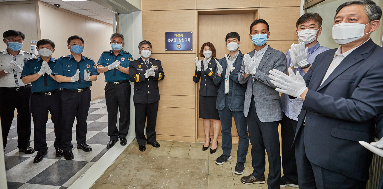 18일 오전 서울 서대문구 경찰청에서 열린 경찰청공무원직장협의회 사무실 현판 제막식. 민갑룡(왼쪽 다섯 번째) 경찰청장, 이소진(오른쪽 다섯 번째) 경찰청공무원직협 대표 등 참석자들이 현판을 제막한 뒤 박수를 치며 자축하고 있다. [경찰청 제공]