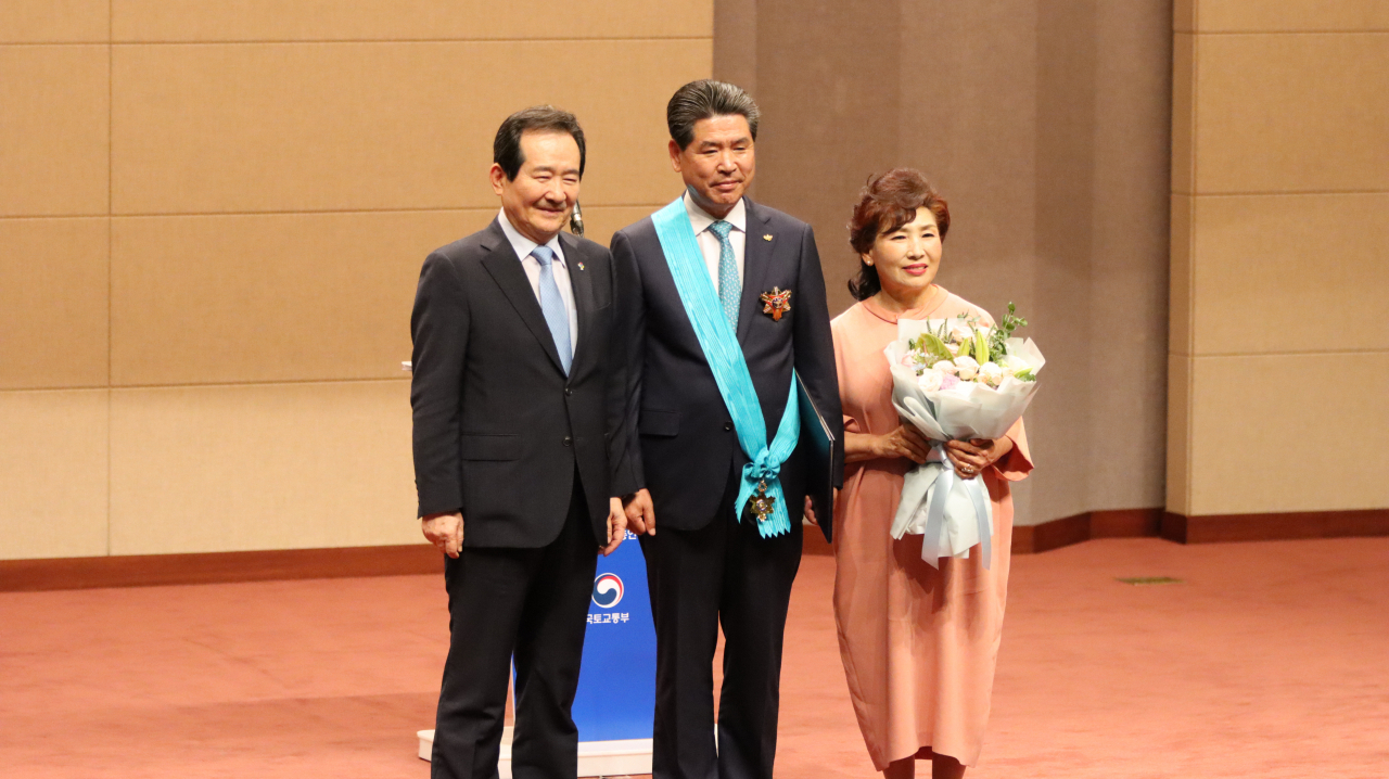 건설의 날 행사에서 정세균 국무총리(왼쪽)가 금탑산업훈장을 받은 윤현우 삼양건설 대표이사(사진 가운데)와 기념촬영을 하고 있다. [대한건설협회]