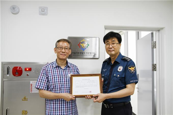 서울 서부경찰서 직장협의회(직협)가 이달 18일 서울 은평구 서부경찰서 내 직협 사무실 앞에서 가진 발족식. 발족식 중 직협 현판을 들고 연명흠 서부경찰서장(오른쪽)과 윤석준 서부경찰서 직협 대표가 기념촬영을 하고 있다. [서울 서부경찰서 제공]