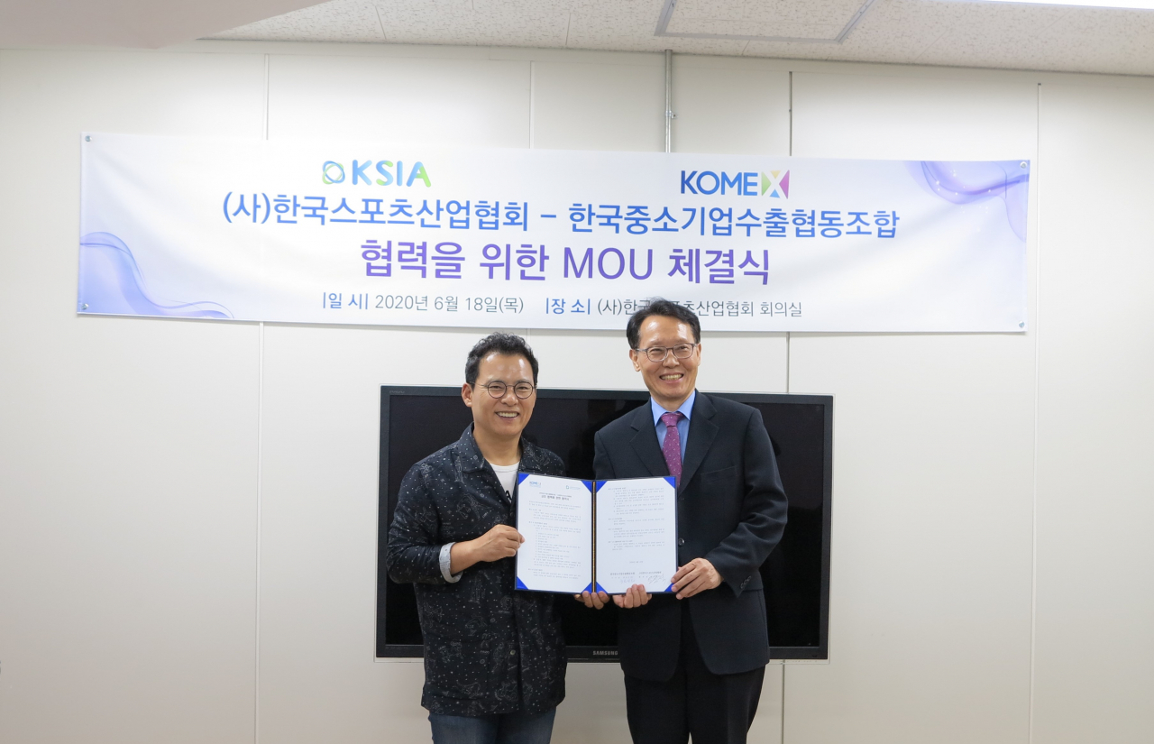 한국스포츠산업협회 오정석(왼쪽) 회장과 한국중소기업수출협동조합 한상곤 이사장이 활짝 웃으며 MOU 협약서를 들어보이고 있다. [한국스포츠산업협회 제공]