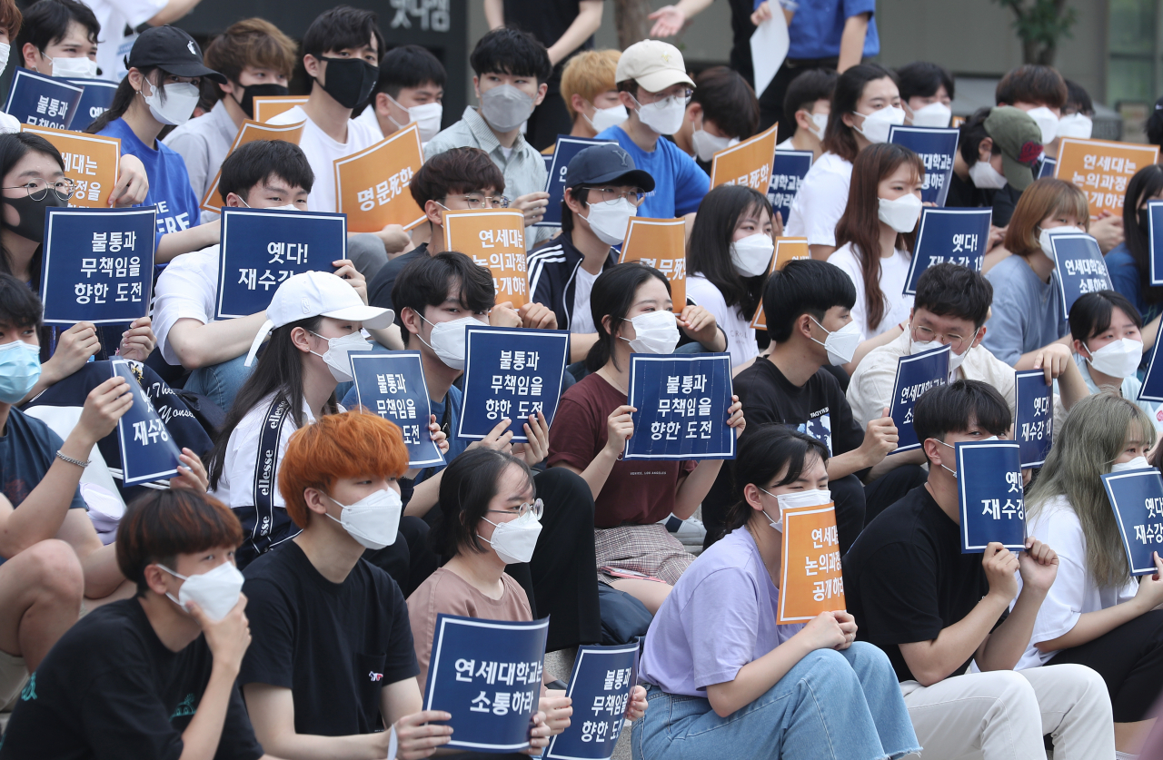 지난 6월 18일 오후 서울 서대문구 연세대 학생회관 앞에서 열린 ‘연세인 총궐기 집회’에서 학생들이 학교에 신종 코로나바이러스 감염증(코로나19) 사태에 따른 성적평가 제도 개선, 등록금 반환 등을 요구하는 내용이 적힌 손피켓을 들고 있다. [연합]