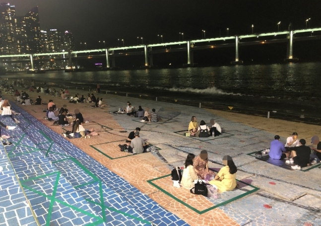 바닥에 청테이프를 붙여 ‘2m 거리두기’를 유도한 부산 수영구 민락수변공원. [부산 수영구 제공]