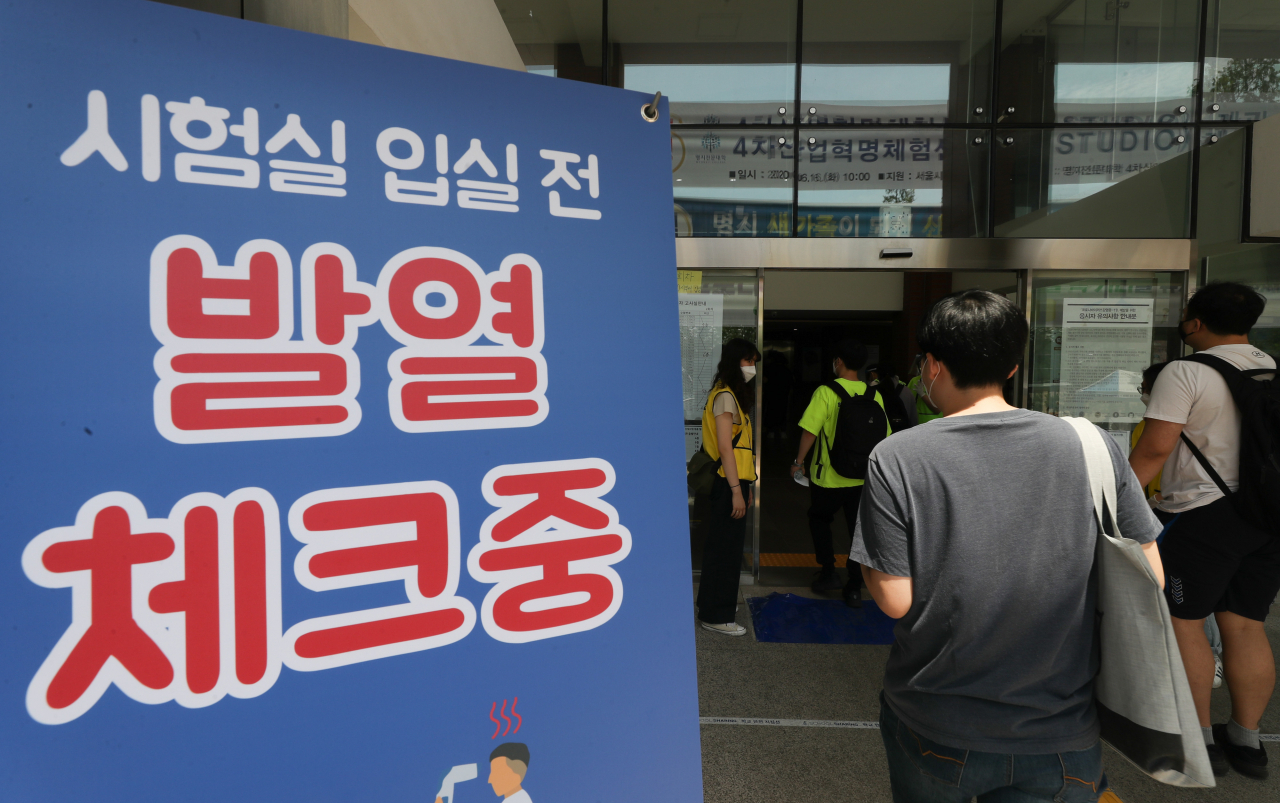 사진은 지난 14일 치러졌던 2020년 상반기 한국철도공사(코레일) 신입사원 채용 필기시험. 응시생들은 서울시내 한 대학에서 고사장 입실 전 체온 측정을 하고 있다. [연합]