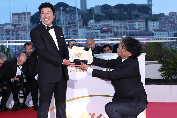 올 칸 영화제 한국 성적표는&hellip;. 2019년 황금종려상을 수상한 봉준호 감독이 '황금종려상'을 배우 송강호에 바치는 퍼포먼스를 하며 환하게 웃고 있다. [게티이미지]