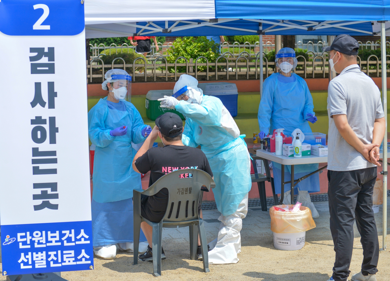 지난 19일 단원구 와동초교 운동장에 마련된 단원보건소 선별진료소에서 의료진이 전교생을 대상으로 전수조사를 하고 있다. [안산시 제공]