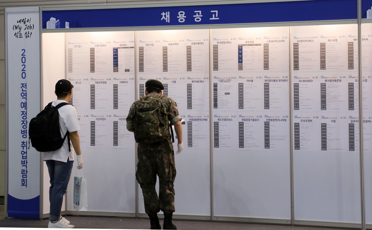 지난 17일 경기도 고양 일산 킨텍스에서 열린 '2020 전역예정장병 취업박람회'에서 장병들이 채용공고판을 꼼꼼하게 살펴보고 있다. ［연합］