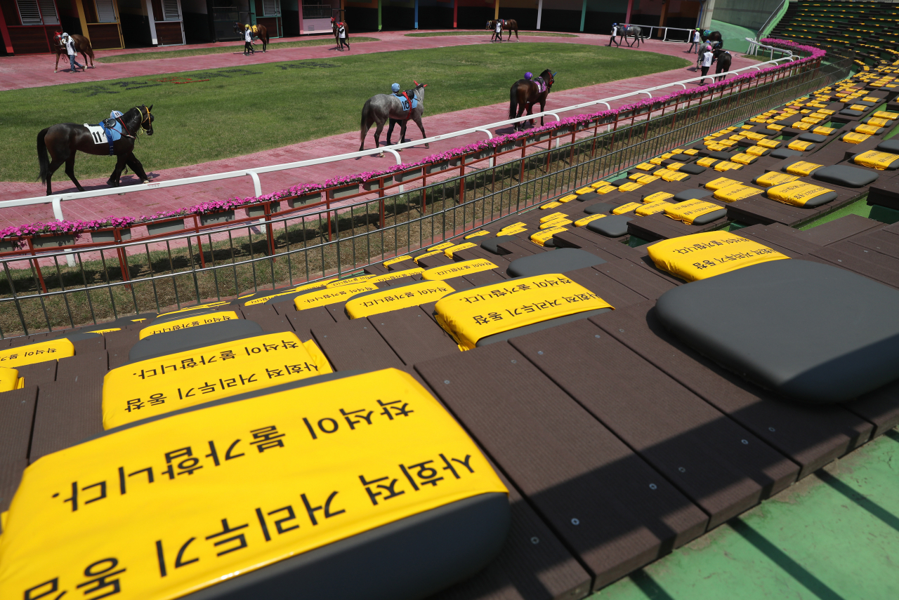 코로나19로 중단됐던 경마가 무관중으로 재개된 21일 과천 렛츠런파크 예시장에서 기수들이 경주마를 선보이고 있다. 연합뉴스