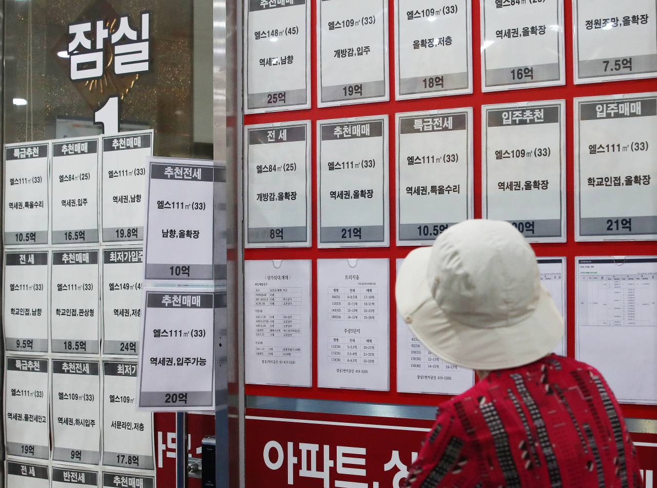 21일 토지거래허가구역으로 지정된 서울 송파구 잠실의 한 부동산 중개업소 앞에서 시민이 매물을 살펴보고 있다. [연합]