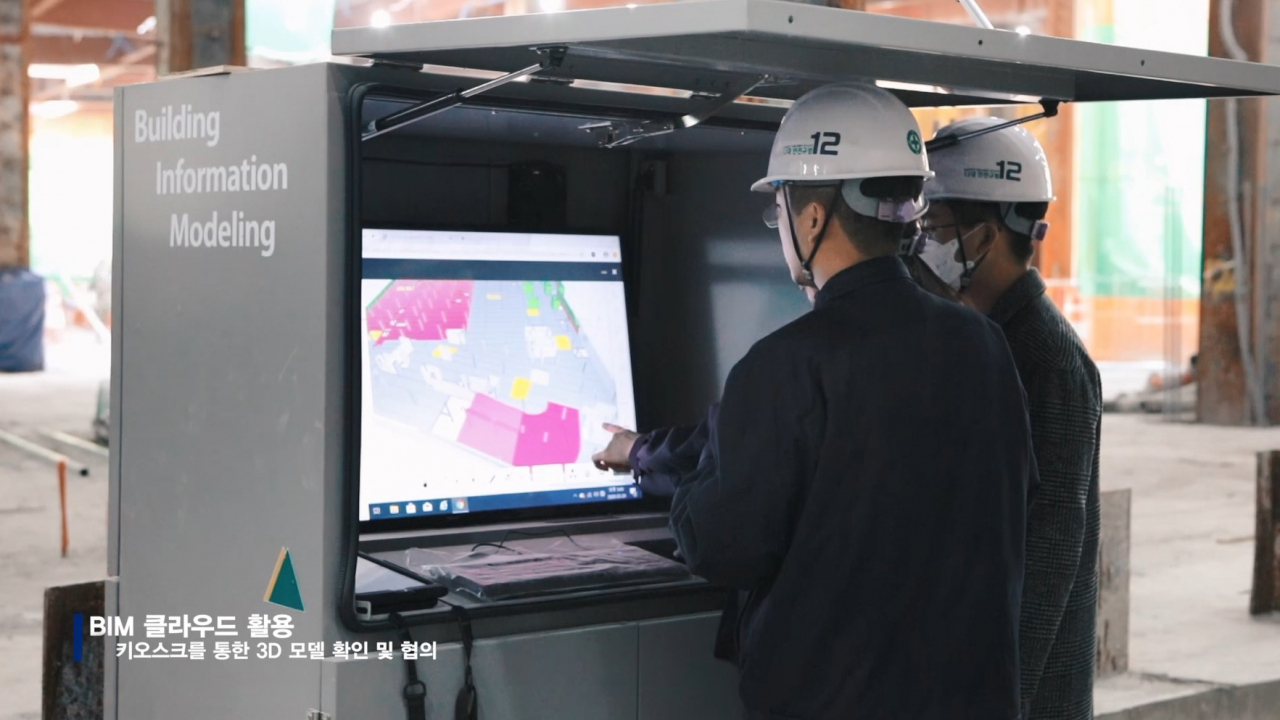 현대엔지니어링이 공사중인 ‘힐스테이트 판교역’ 현장에서 엔지니어들이 BIM 클라우드가 내장된 키오스크를 활용해 현장 3D 모델을 검토하고 있다. [현대엔지니어링 제공]