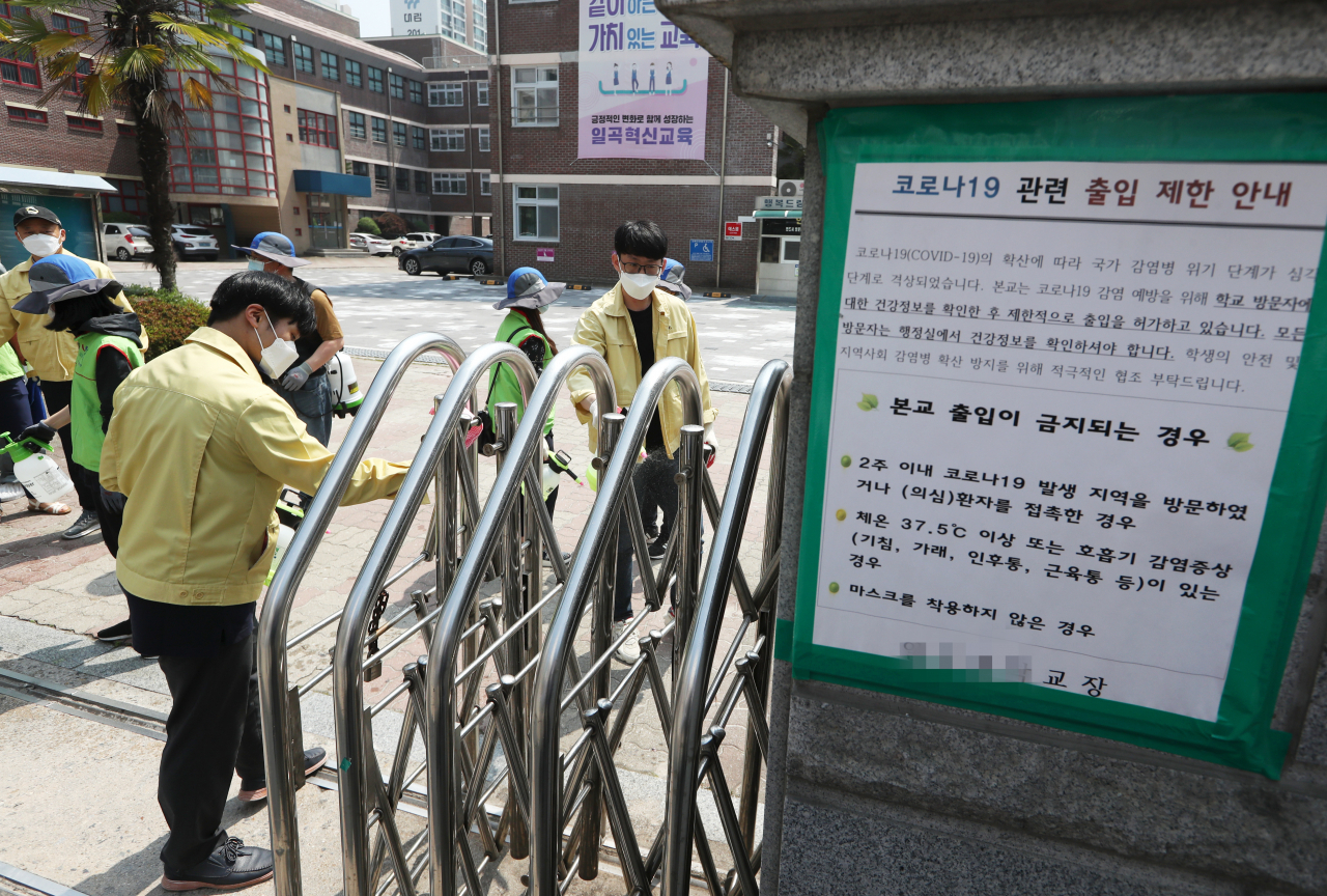 22일 오전 광주 북구 일곡동의 한 학교에서 행정복지센터 방역반원과 북구보건소 직원들이 방역하고 있다. 지난 20일 신종 코로나바이러스 감염증(코로나19) 양성판정을 받은 광주 33번 확진자의 동선 주변 39개 학교는 23일까지 원격수업을 진행한다. [연합]