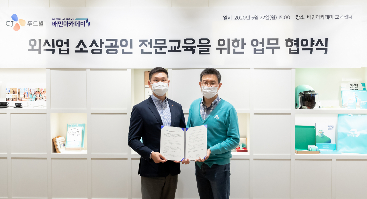 우아한청년들 백선웅 이사(오른쪽)와 CJ푸드빌 김찬호 상무가 22일 서울 송파구 배민아카데미에서 열린 '외식업 소상공인 전문교육을 위한 업무협약식'에서 기념촬영을 하고 있다.(사진=우아한형제들)