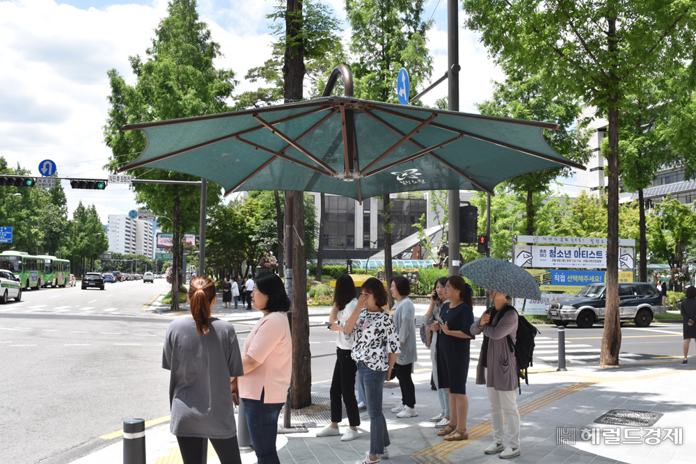 노원구 횡단보도 앞에 설치된 그늘막에서 시민들이 뜨거운 햇빛을 피하고 있다. [노원구 제공]