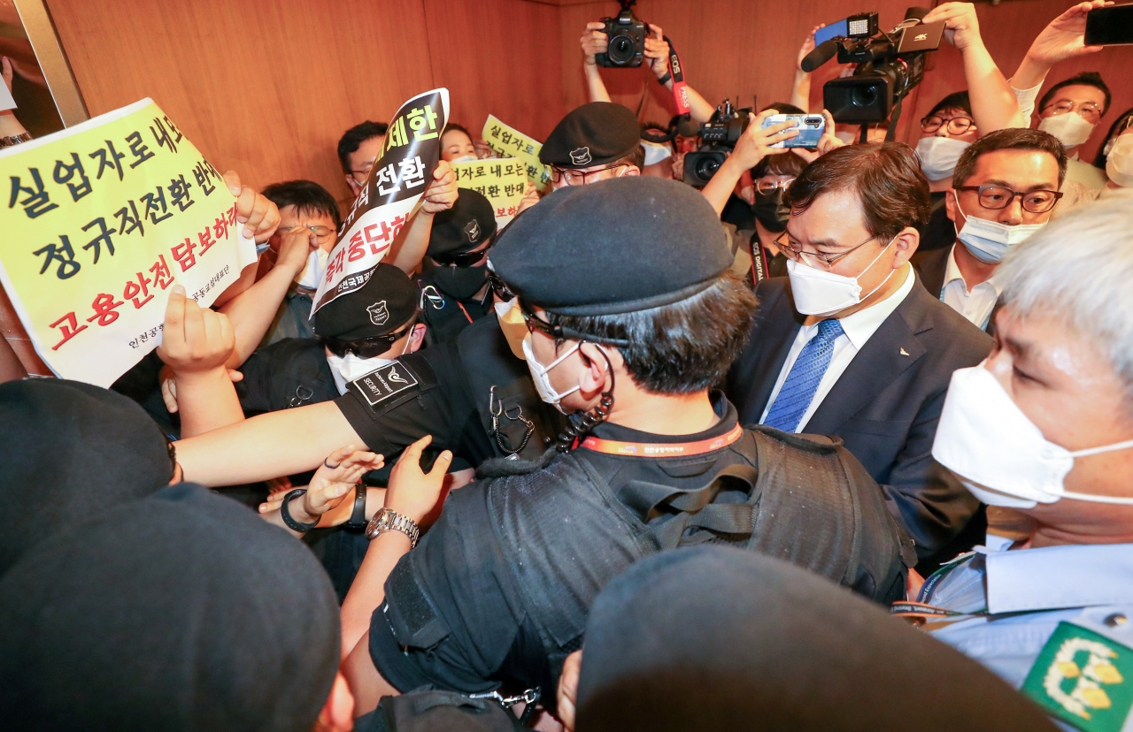 지난 22일 인천국제공항 제1여객터미널에서 보안검색 노동자 정규직화 관련 브리핑을 마친 구본환 인천국제공항공사 사장이 브리핑실을 나와 엘리베이터로 이동하던 중 직원들의 거센 항의를 받고 있다. [연합]