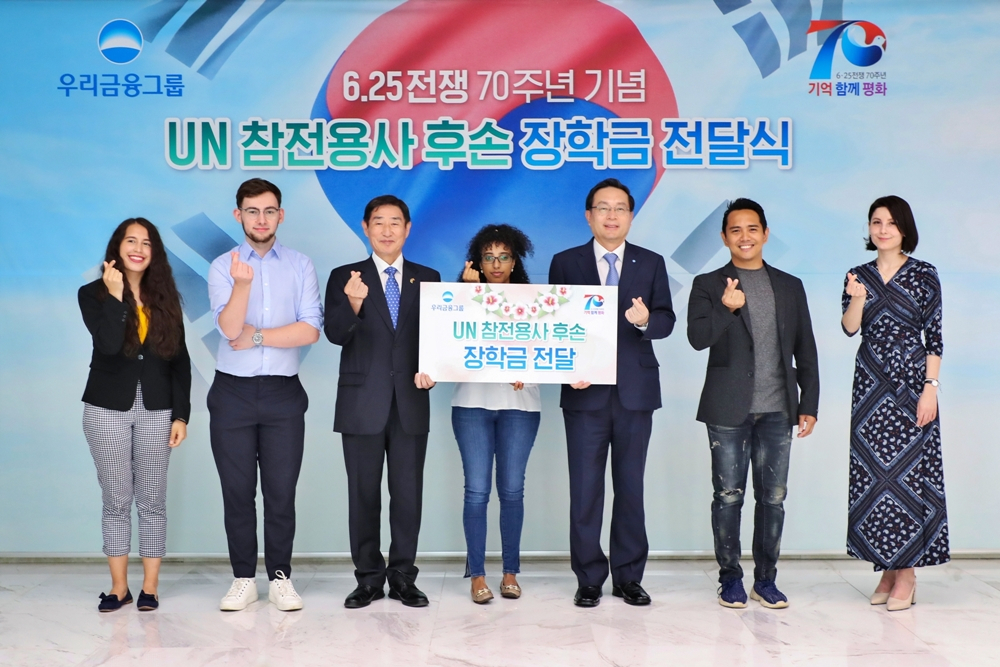 22일 서울 중구 회현동 우리금융그룹 본사에서 열린 UN 참전용사 후손 장학금 전달식에서 손태승(왼쪽 다섯번째) 우리금융 회장, 김은기(왼쪽 세번째) 6·25전쟁 70주년 사업추진위원회 공동위원장이 참전용사 후손들과 기념촬영을 하고 있다. [우리금융 제공]
