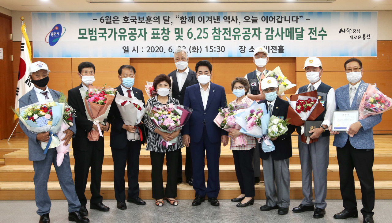 백군기 용인시장이 호국보훈의 달을 맞아 표창을 수여한 국가유공자 등과 기념촬영을 하고있다. [용인시 제공]