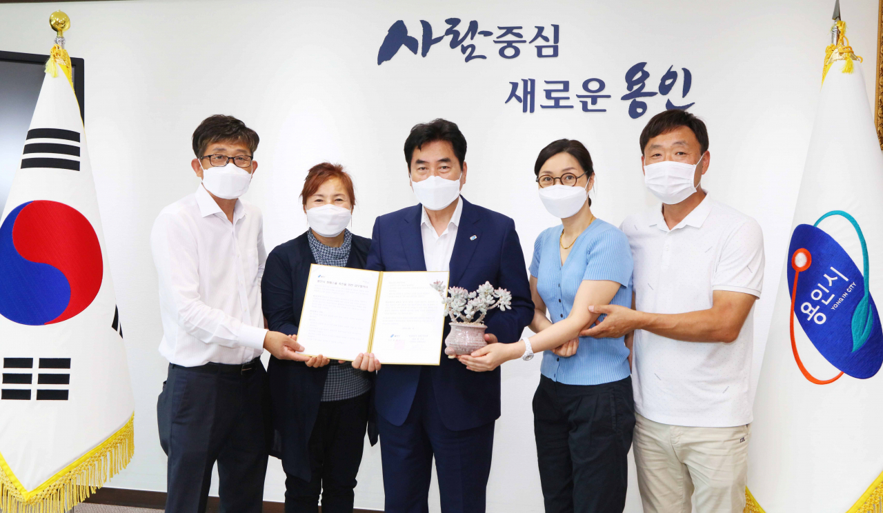 백군기 용인시장이 지난 22일 미르영농조합 관계자들과 캄보디아 수출 촉진 협약서를 들고 기념촬영을 하고있다. [용인시 제공]