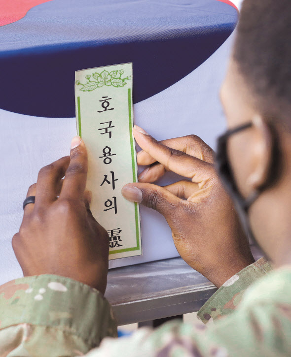 22일(현지시간) 미국 하와이 국방부 전쟁포로 및 실종자 확인국(DPAA)에서 미국 장병들이 한국군 유해를 관포한 후 ‘호국용사의 靈’이라는 표를 붙이고 있다. [연합]