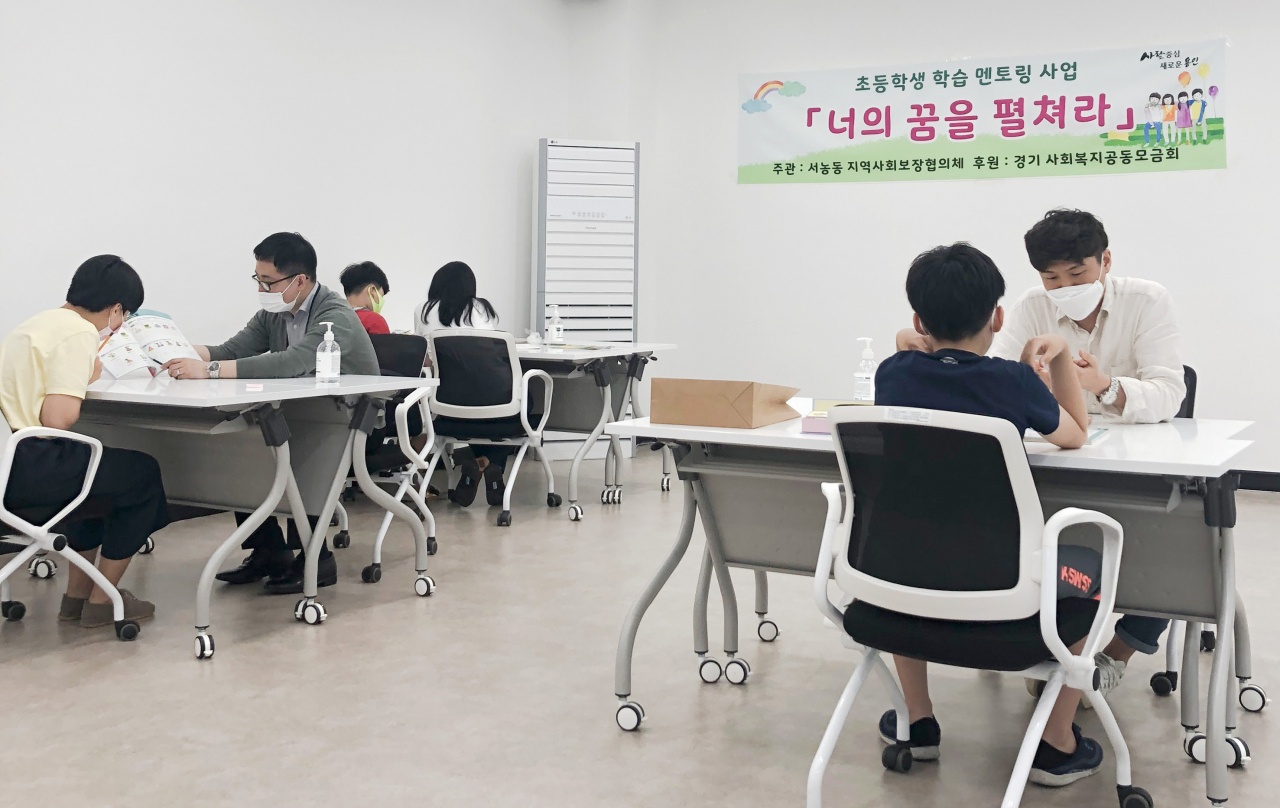 지난 23일 서농동 행정복지센터에서 자원봉사자들이 초등생 학습 지도를 하고있다. [용인시 제공]