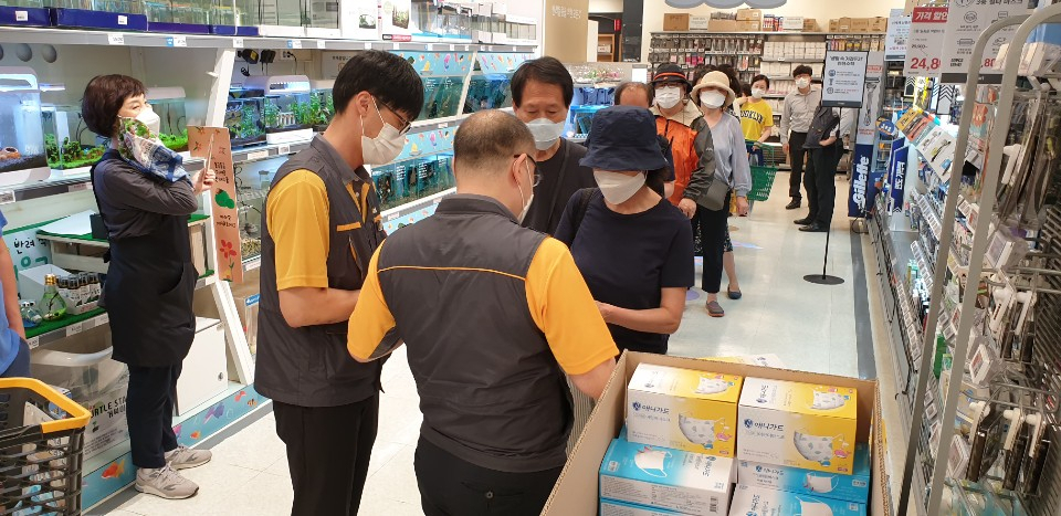 지난 24일 오후 2시 이마트 용산점에서 번호표를 받은 사람들이 비말 차단용(KF-AD) 마스크를 받고 있다. [사진=박재석 기자]