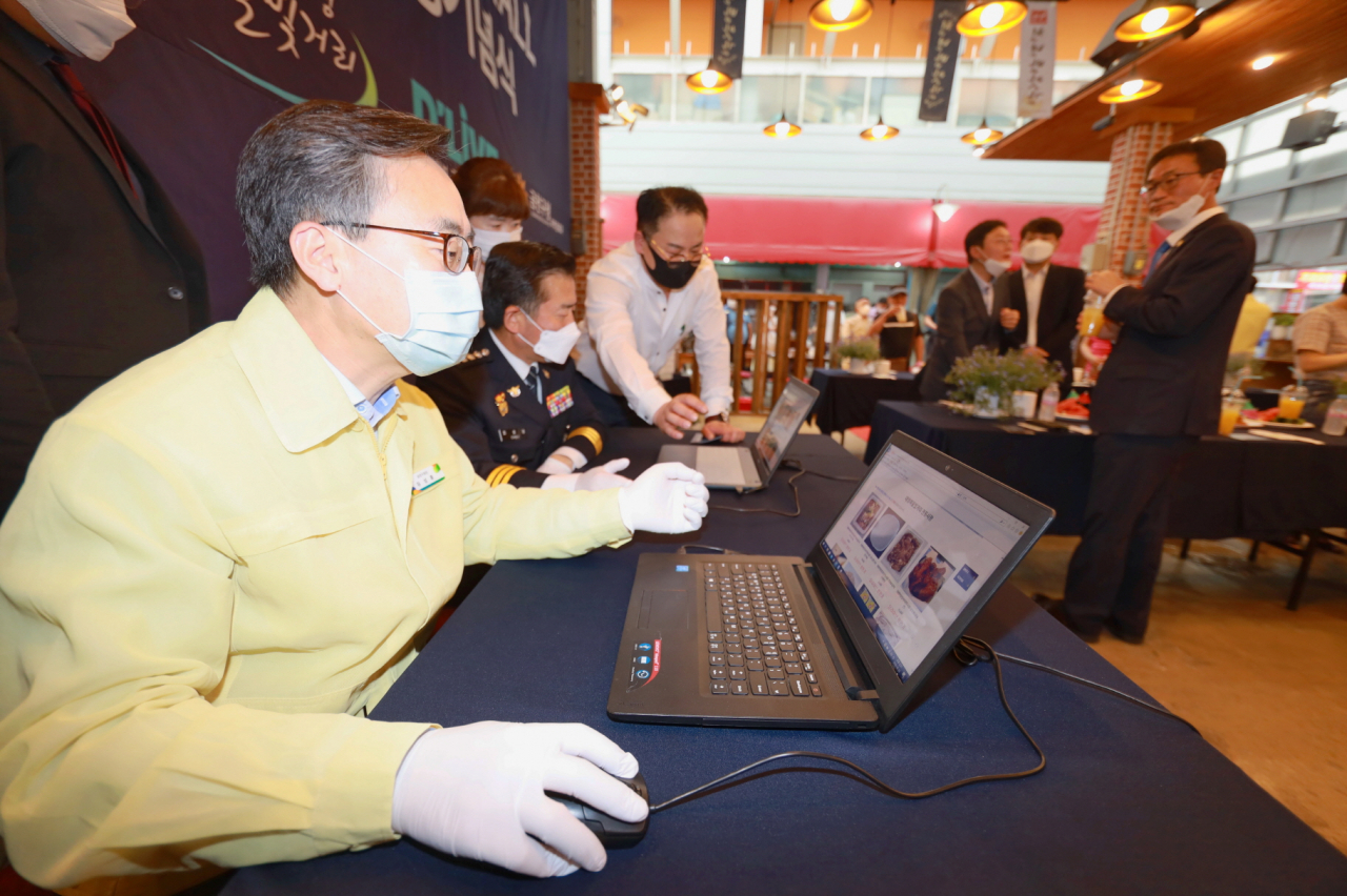 지난 23일 개최된 ‘대명여울빛거리시장, 딜라이브몰 런칭기념식’에서 유성훈 금천구청장이 온라인을 통한 물건구매를 시연하고 있다. [금천구 제공]