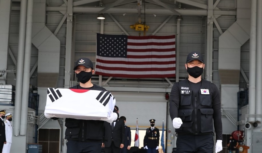 Members of South Korea's Agency for KIA Recovery & Identification carry flag-draped caskets of war dead remains at Joint Base Pearl Harbor-Hickam in Hawaii on June 23, 2020 in this photo provided by the Defense Media Agency provided this photo. (PHOTO NOT FOR SALE) (Yonhap)