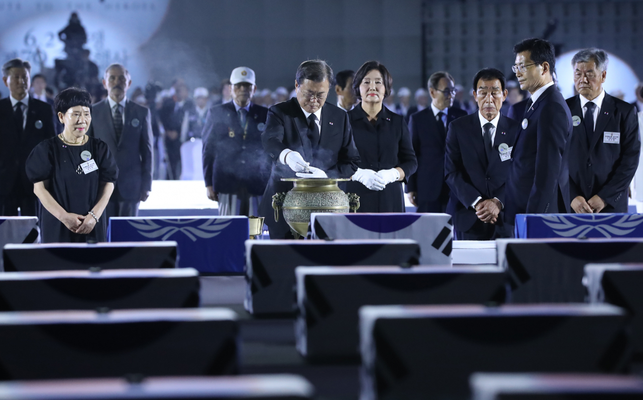 문재인 대통령과 부인 김정숙 여사가 25일 서울공항에서 열린 6·25전쟁 70주년 행사에서 유족과 함께 분향하고 있다. [연합]