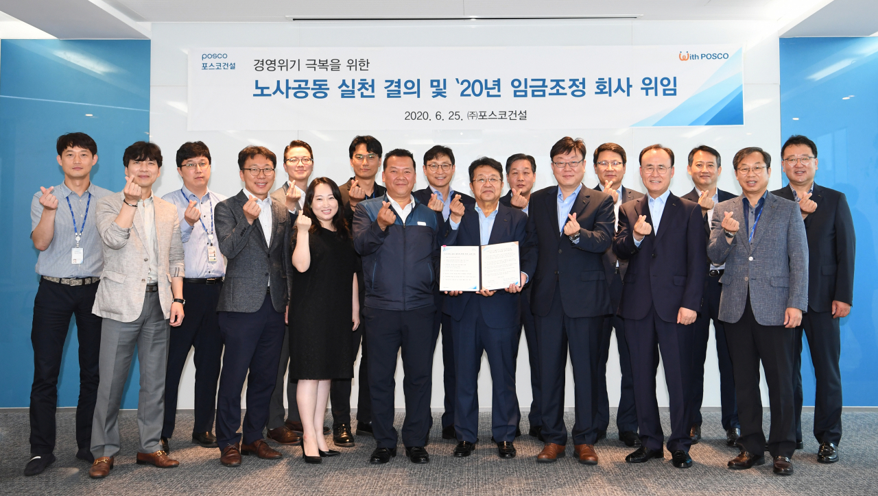 포스코건설 노사공동실천 결의식. 왼쪽 첫째줄 네 번째부터 김원훈 노동조합위원장, 한성희 포스코건설 사장과 노경협의회 김윤중 대표가 노사공동실천 결의식을 갖고 기념촬영을 하고있다. [포스코건설제공]