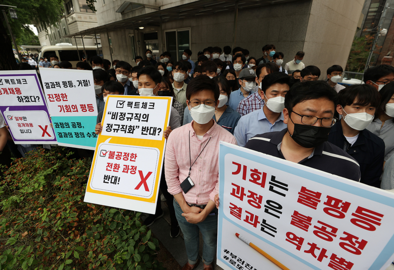 인천국제공항공사노동조합 소속 조합원들이 25일 오후 서울 청와대 인근에서 열린 기자회견에서 비정규직 보안검색 요원들의 정규직 전환 관련 입장을 발표하며 손팻말을 들고 있다.[연합]