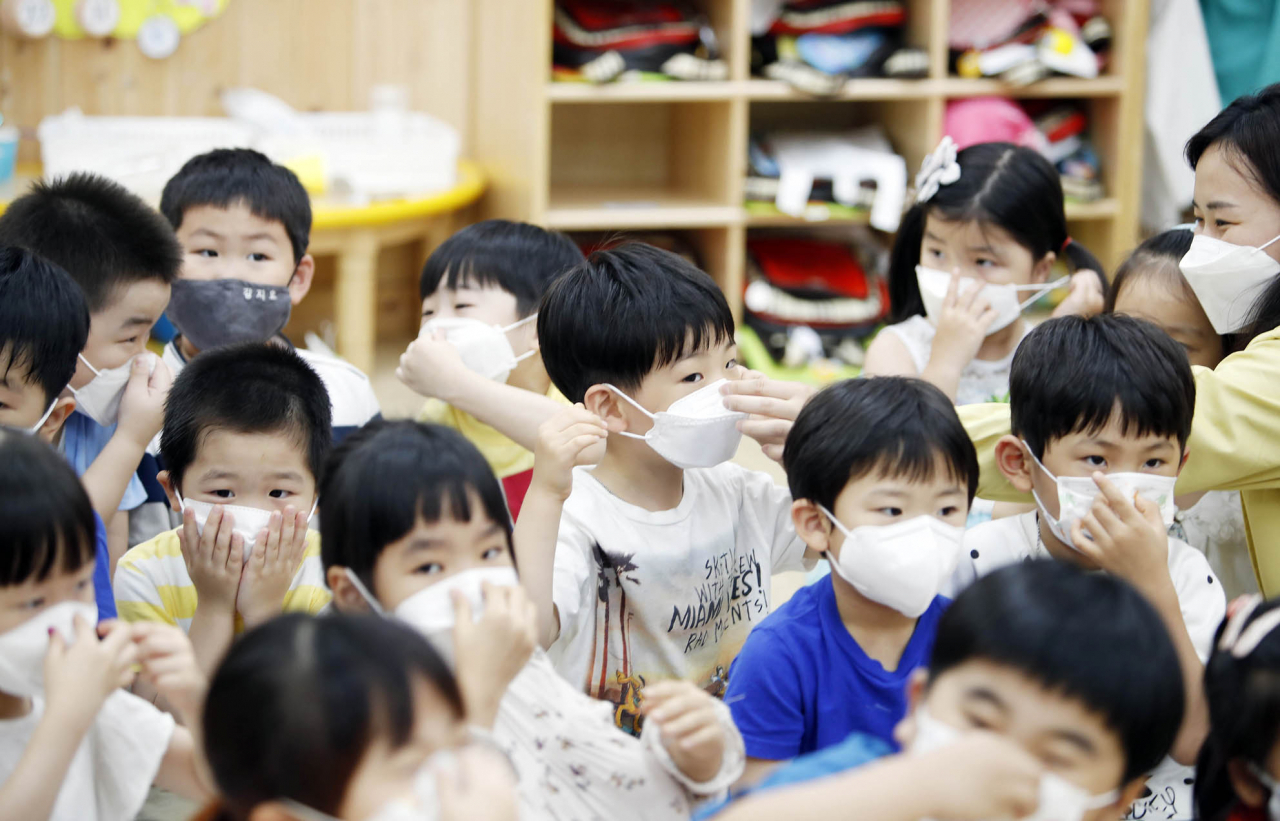 26일 오전 광주 북구청 직장어린이집에서 구청 보육지원팀 직원들이 아이들을 대상으로 코로나19 등 감염병 예방을 위해 마스크 쓰는 법을 알려주고 있다. [연합]