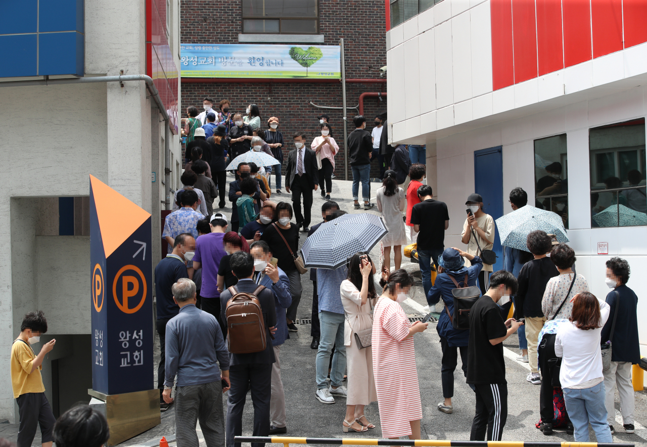 26일 신종 코로나바이러스 감염증(코로나19) 확진자가 발생한 서울 관악구 왕성교회에 설치된 임시 선별진료소에서 교인들이 검체 채취를 받기 위해 줄지어 서 있다. [연합]