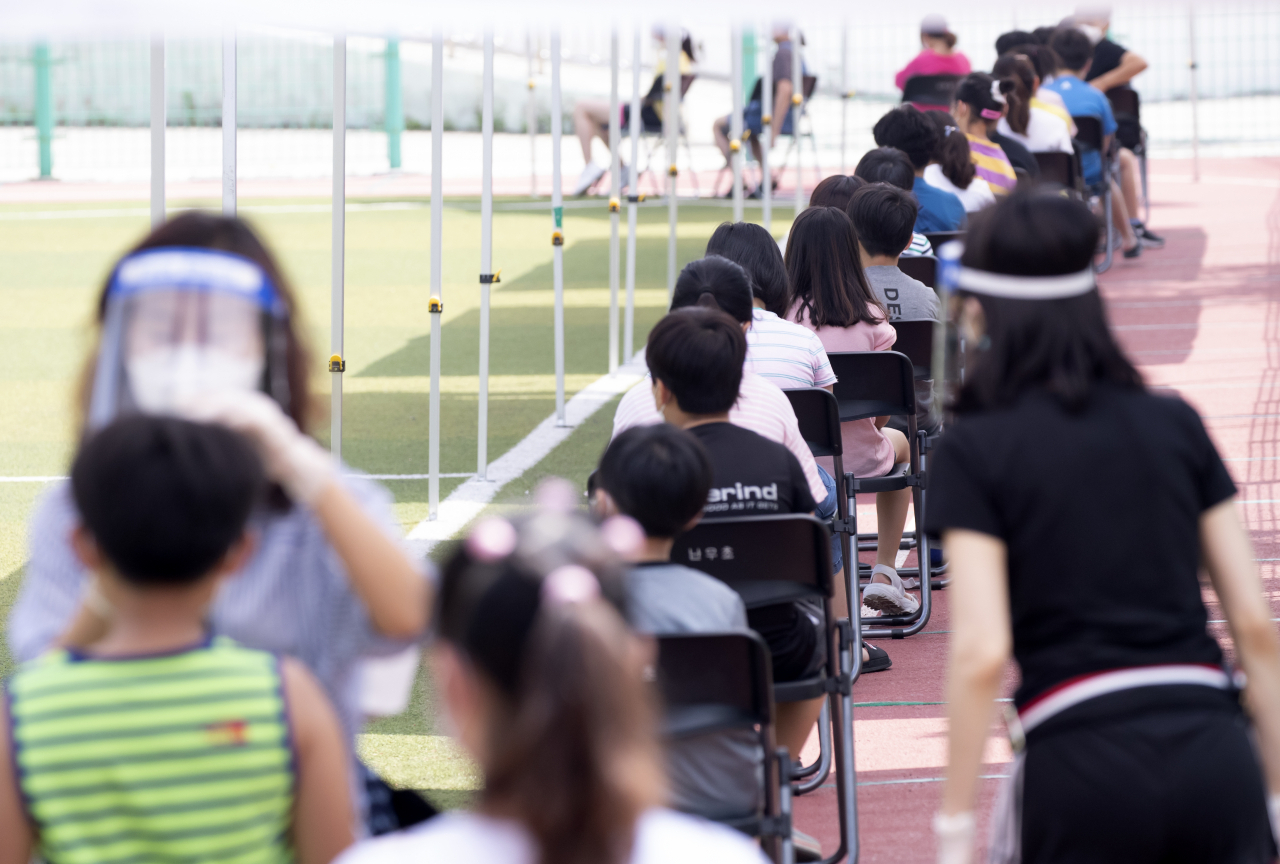 28일 오전 서울 관악구 난우초등학교에 설치된 선별진료소에서 학생들이 코로나19 검사를 받기 위해 대기 중이다. 왕성교회 감염자 중 한 명이 난우초 시간강사인 것으로 확인돼 방역당국은 이날 학교 학생과 교직원을 대상으로 긴급 검사에 나섰다. [연합]
