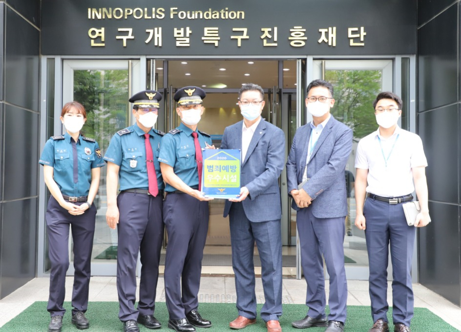 김인신(왼쪽 4번째) 특구진흥재단 경영관리실장이 유성경찰서로부터 범죄예방 우수시설 인증패를 받고 있다.[연구개발특구진흥재단 제공]