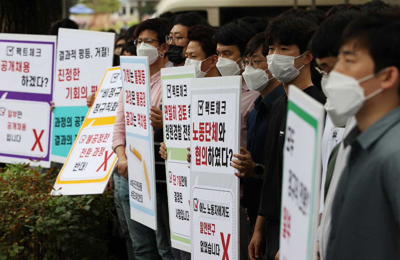 인천국제공항공사노동조합 소속 조합원들이 25일 오후 서울 청와대 인근에서 열린 기자회견에서 비정규직 보안검색 요원들의 정규직 전환 관련 입장을 발표하며 손팻말을 들고 있다. [연합]
