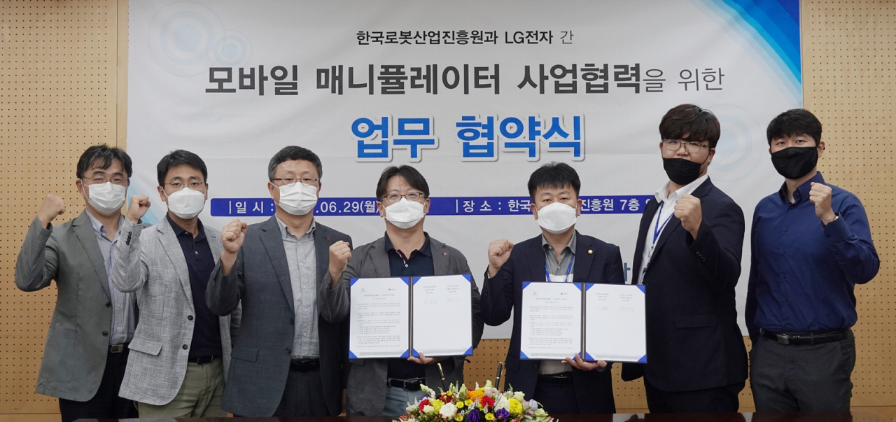 : LG전자와 한국로봇산업진흥원이 산업용 자율주행로봇 ‘모바일 매니퓰레이터(Mobile Manipulator)’의 안전성을 높이기 위해 29일 업무협약을 체결했다.(LG전자 생산기술원 이승기 선행생산기술연구소장(왼쪽에서 네 번째)과 한국로봇산업진흥원 우종운 인증평가사업단장(왼쪽에서 다섯 번째)) [LG전자 제공]