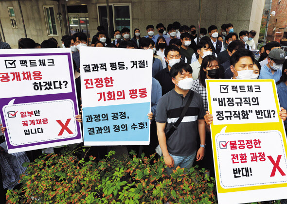 인천국제공항공사노동조합 소속 조합원들이 서울 청와대 인근에서 열린 기자회견에서 비정규직 보안검색 요원들의 정규직 전환 관련 입장을 발표하며 손팻말을 들고 있는 모습. [연합]