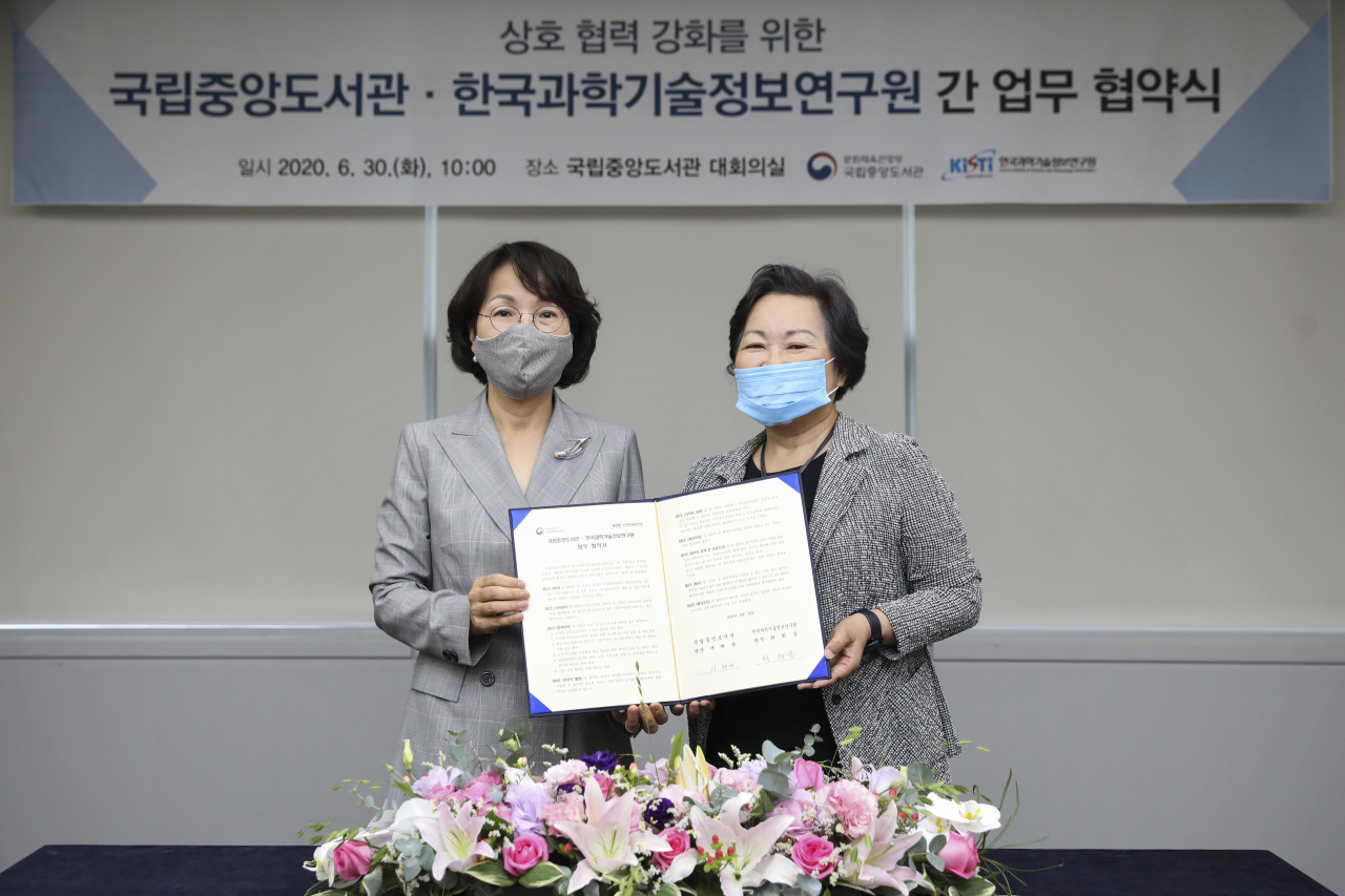 최희윤(왼쪽) KISTI 원장과 서혜란 국립중앙도서관장이 업무협약을 체결하고 있다.[국립중앙도서관 제공]