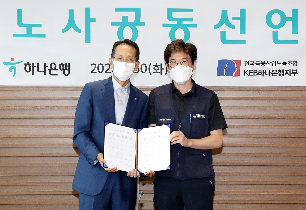 30일 오전 서울 을지로 하나은행 본점에서 지성규 은행장(왼쪽)과 최호걸 노조위원장이 노사 공동선언문에 서명하고 기념촬영을 하고 있다. [하나은행 제공]
