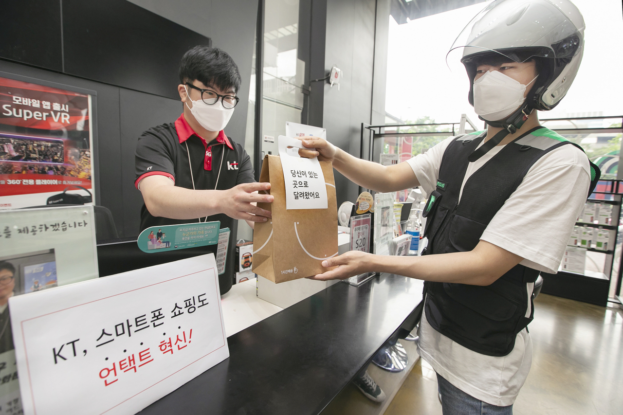 KT 대리점 직원이 부릉 라이더에게 ‘1시간배송’ 서비스를 통한 핸드폰 배송을 요청하고 있다. [KT 제공]