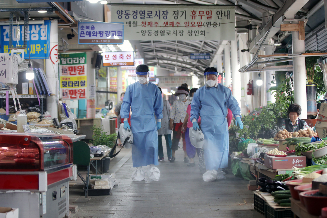 29일 오전 광주 서구 양동시장 인근에서 방역당국 관계자들이 소독을 하고 있다. 전남 21번 확진자와 광주 34번 확진자는 지난 23일 양동시장 인근 상점에 들른 것으로 조사됐다. [연합]
