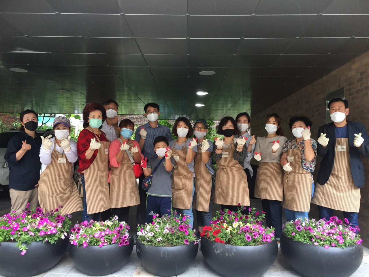 단대동 주민들이 사피니아를 직접 심고 화분 앞에서 포즈를 취하고 있다. [성남시 제공]