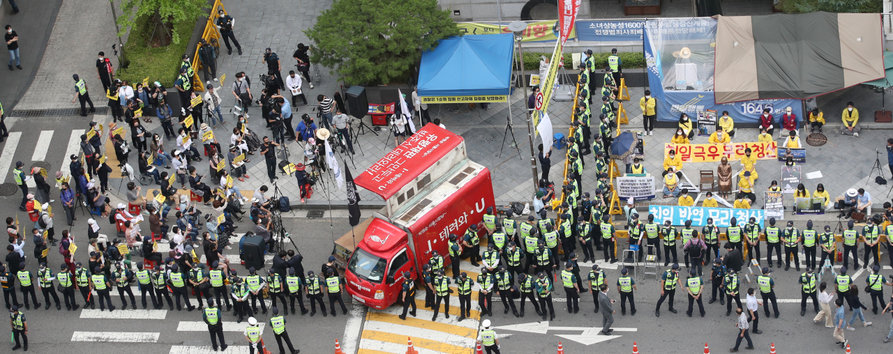 지난 1일 오후 서울 종로구 옛 일본대사관 맞은편에서 소녀상 철거 등을 요구하는 집회와 이를 막으려는 대학생단체 반아베반일청년학생공동행동의 소녀상 연좌시위가 동시에 열리고 있다. [연합]