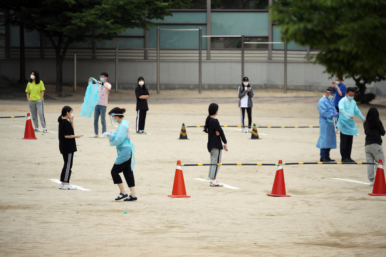 신종 코로나바이러스 감염증(코로나19) 확진자가 나온 것으로 알려진 대구 수성구 대구 남산고등학교 운동장에 3일 오전 선별진료소가 차려져 학생들이 코로나19 검사를 받기위해 거리를 두고 서 있다. [연합]
