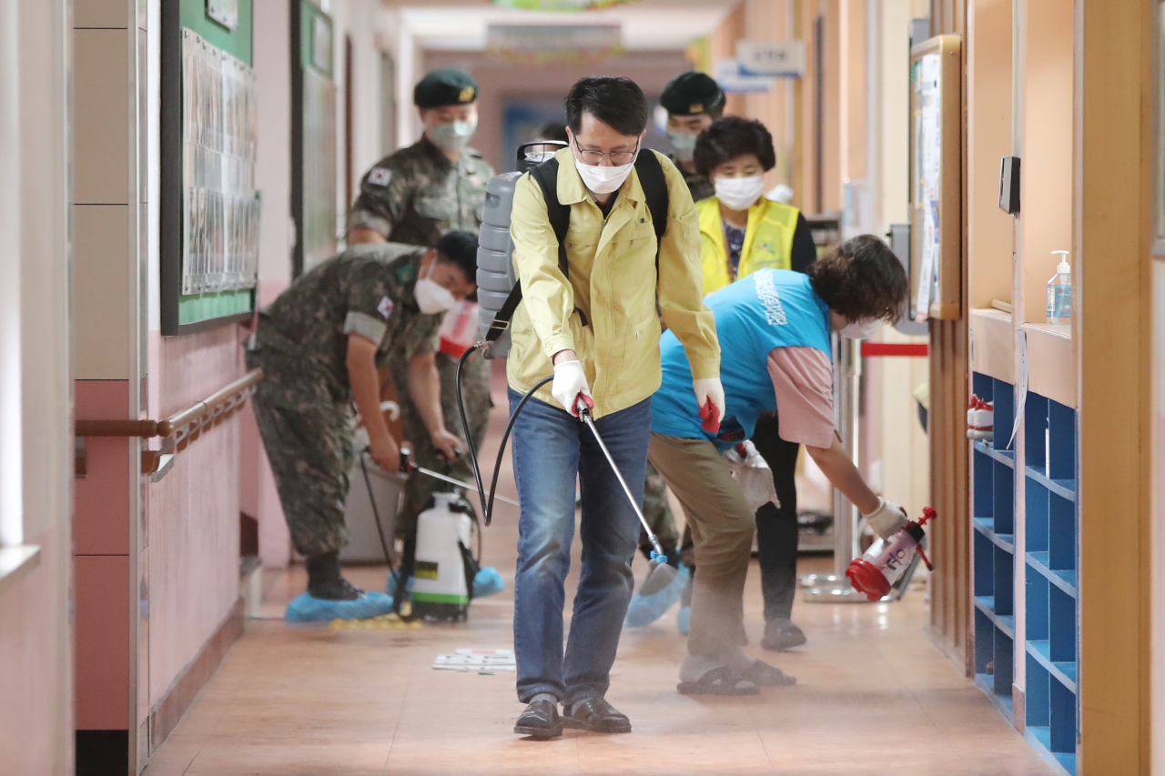 3일 오전 광주 북구 한 초등학교에서 운암1동 행정복지센터 관계자들이 오는 6일부터 재개되는 학생 등교수업에 대비해 소독하고 있다. [연합]