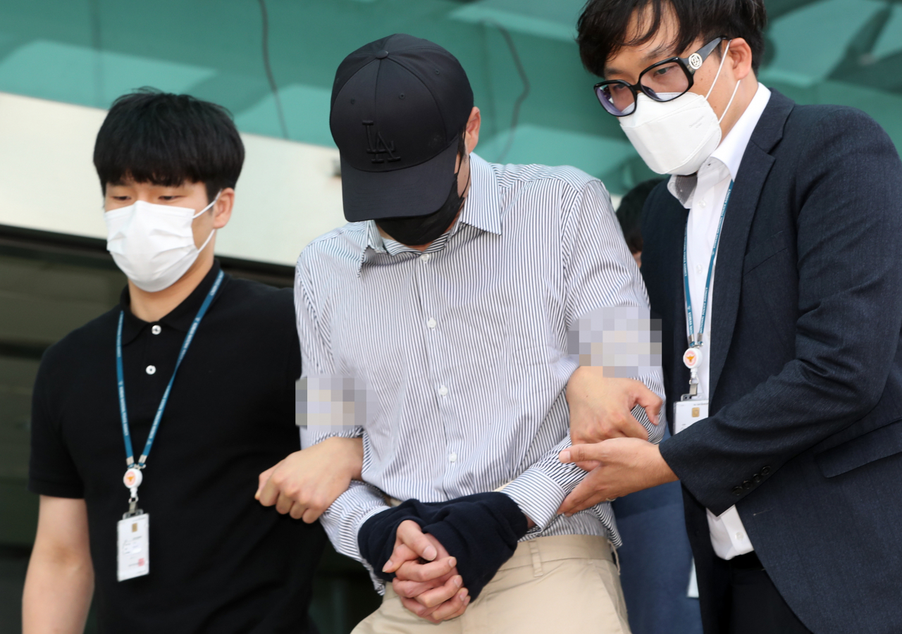 텔레그램 'n번방'에서 아동·청소년 성 착취물을 구매하는 등 아동·청소년의 성보호에 관한 법률(약칭 청소년성보호법) 위반 등으로 구속된 A(38)씨가 검찰로 송치되기 위해 호송차량으로 향하고 있다. [연합]