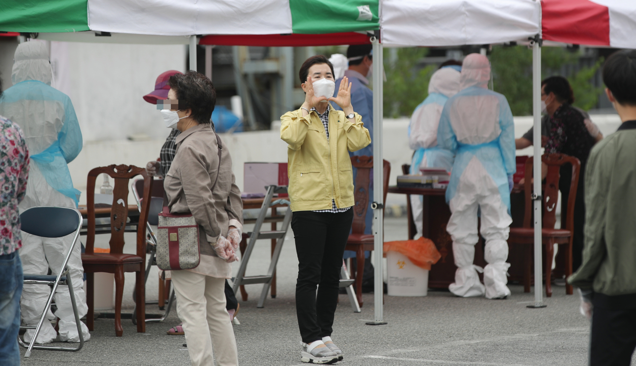 4일 오전 광주 북구 일곡중앙교회 주차장에 마련된 선별진료소에서 방역당국 관계자가 신종 코로나바이러스 감염증(코로나19) 검사를 받기 위해 줄을 선 교인들을 상대로 자가격리 지침을 전하고 있다. 지난달 27&sim;28일 이 교회 예배에 참석한 800여명 가운데 5명이 코로나19 확진 판정을 받았다. 연합뉴스